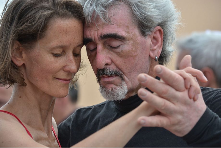 Ein Mann und eine Frau in Portrait Ansicht tanzen Tango mit einem sehr verinnerlichten und gefühlvollen Gesichtsausdruck