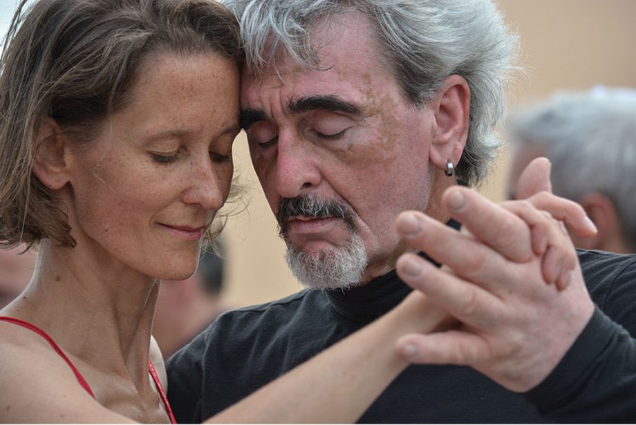 Ein Mann und eine Frau in Portrait Ansicht tanzen Tango mit einem sehr verinnerlichten und gefühlvollen Gesichtsausdruck